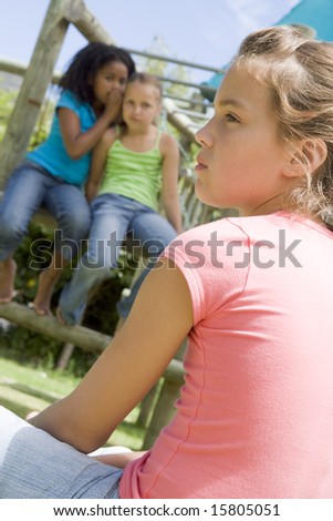 stock photo Two young girl friends at a playground whispering about other 