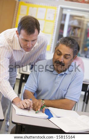 Teacher assisting mature student in class