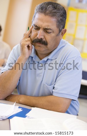 Mature male student frowning in class