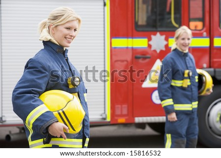 stock photo : Two female firefighters by a fire engine