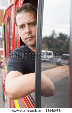 Male firefighter sitting in the cab of a fire engine