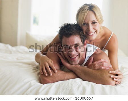 man and women laying on a bed