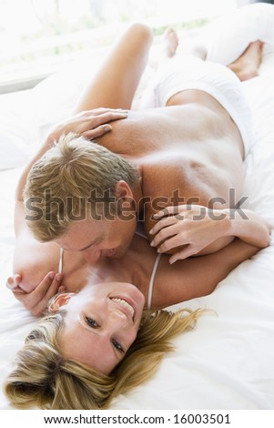 man and women cuddling together on a bed