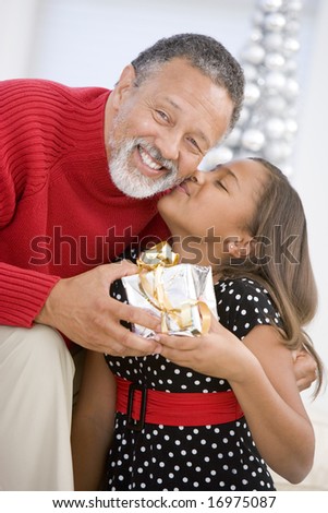 Grandfather Giving His Granddaughter A Christmas Present