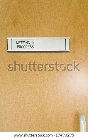 A Closed Office Door, With \'Meeting In Progress\' Sign
