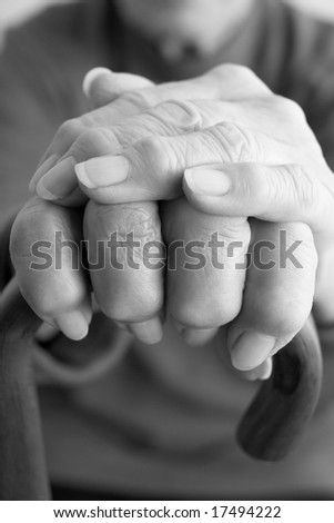 Close-Up Of Elderly Persons Hand Resting On Walking Cane
