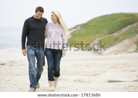 Couple walking at beach smiling