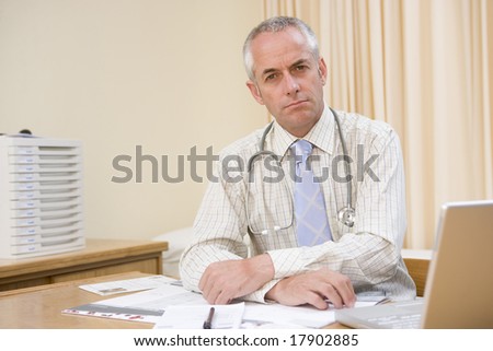 Doctor doing paperwork at desk