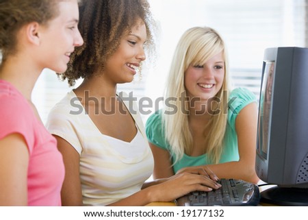 Teenage Girls Sitting Around A Computer