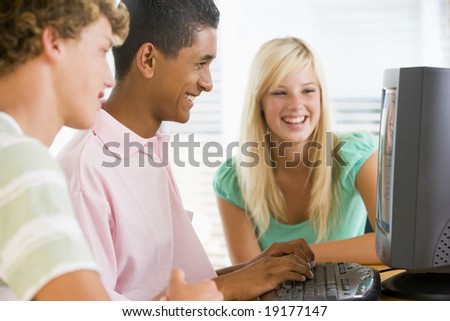 Teenagers Sitting Around A Computer