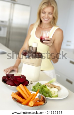 Mid Adult Woman Making Fresh Vegetable Juice