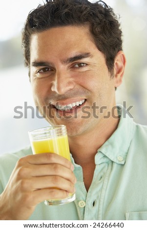 Mid Adult Man Holding A Glass Of Fresh Orange Juice, Smiling At The Camera