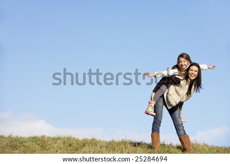Mother Giving Her Daughter A Piggy Back Ride