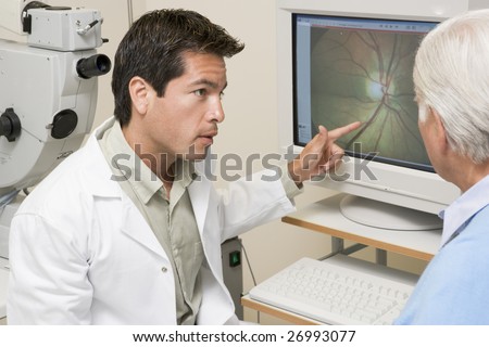 Doctor Explaining Eye Exam Results To Patient