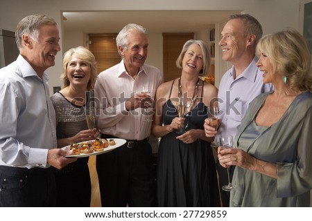 Man Serving Hors D\'oeuvres To His Guests At A Dinner Party