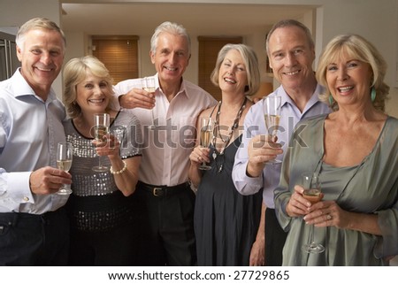 Friends Enjoying A Glass Of Champagne At A Dinner Party