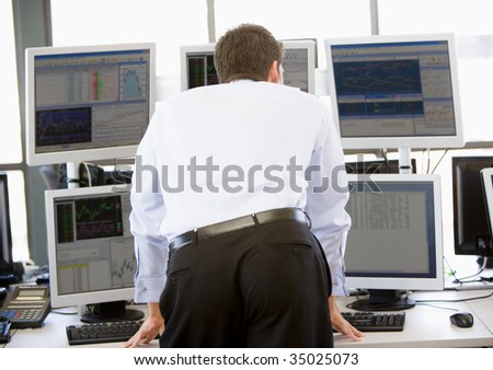 Stock Trader Looking At Multiple Monitors