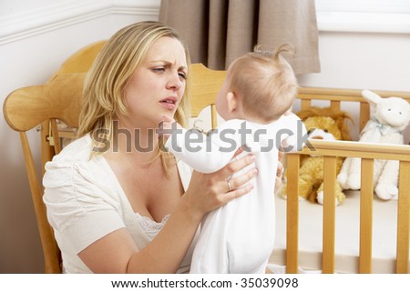 Stressed Mother Holding Baby In Nursery