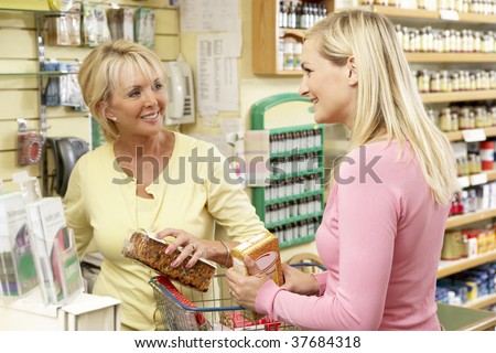Sales assistant with customer in health food store