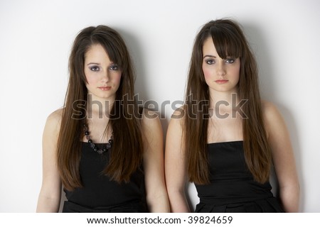 stock photo Studio Portrait Of Fashionably Dressed Twin Teenage Girls