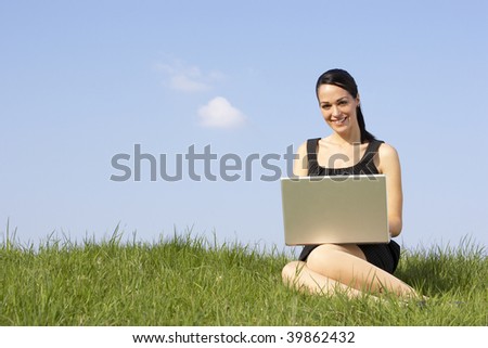 Woman Using Laptop Outdoors In Summer Countryside