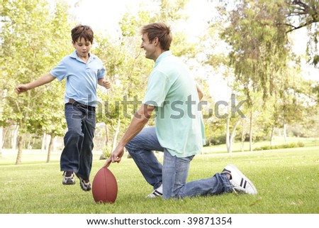 Father And Son Playing American Football Together