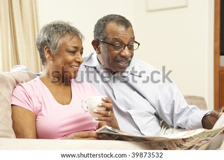 Senior Couple Reading Newspaper At Home