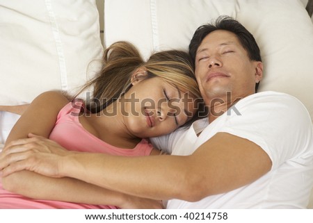 Young Couple Asleep In Bed