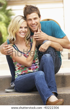 Young Couple Sitting On Steps Of Building