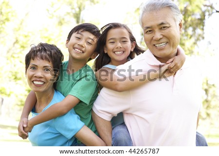 Portrait Of Grandparents With Grandchildren In Park