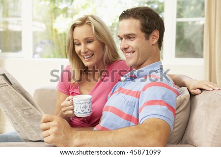 Couple Reading Newspaper At Home