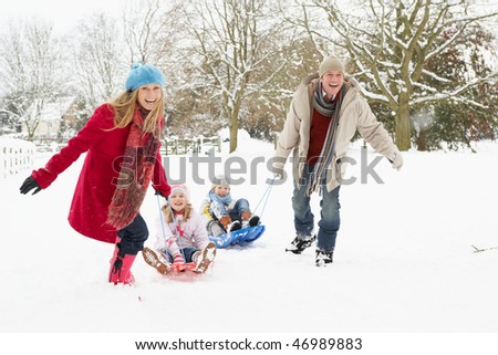 Family Pulling Sledge Through Snowy Landscape