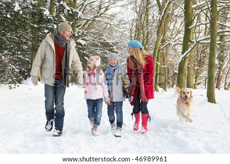 Family Walking Dog Through Snowy Woodland