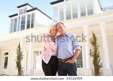 Senior Couple Standing Outside Dream Home