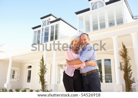Senior Couple Standing Outside Dream Home