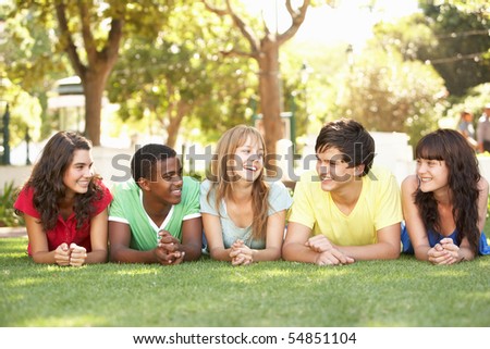 Group Of Teenagers Lying On Stomachs In Park