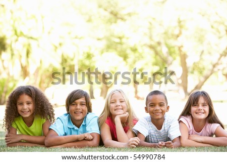 Group Of Children Lying On Stomachs In Park