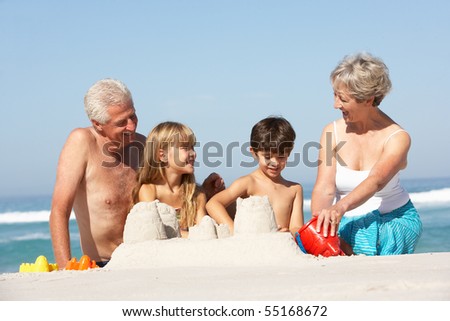 Grandparents And Grandchildren Building Sandcastles Together On Beach Holiday
