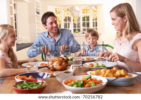 stock photo Happy family having roast chicken dinner at table