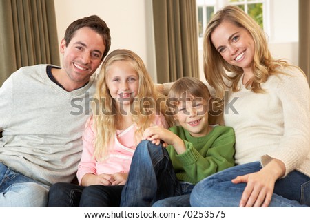 Happy young family sitting on sofa