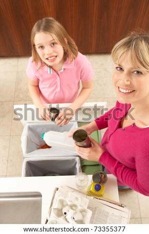 Mother And Daughter Recyling Waste At Home