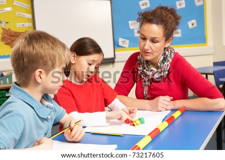 School Children Studying In Classroom With Teacher