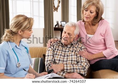 Senior Couple Talking To Health Visitor At Home