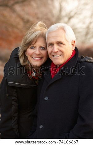 Senior Couple On Winter Walk Through Frosty Landscape