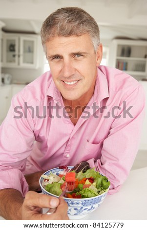 Mid age man eating salad