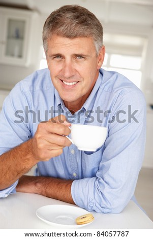 Mid age man with coffee at home