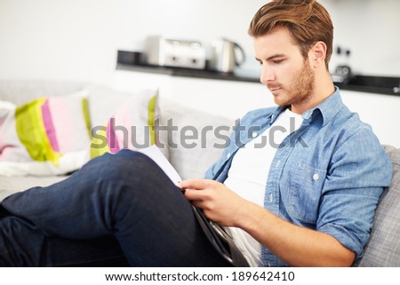 Young Man Looking Through Personal Finances At Home