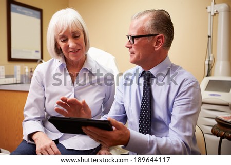 Cosmetic Surgeon Discussing Proceedure With Client In Office