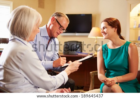 Older Couple Talking To Financial Advisor In Office