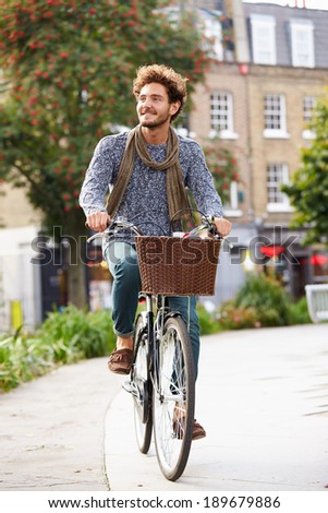 Young Man Cycling Through Urban Park